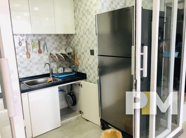 kitchen with fridge freezer in yangon apartment for rent