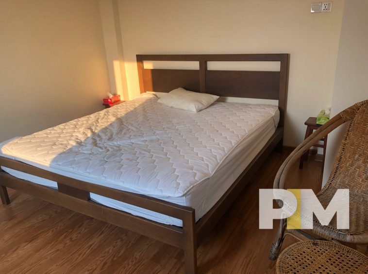bedroom with rattan chair in sanchaung penthouse for rent