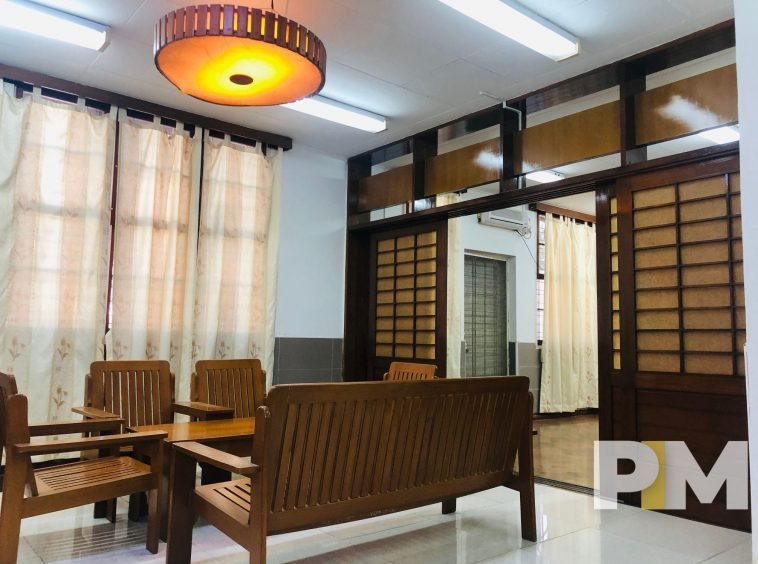 living room with wooden table and charis - proeprty in Yangon